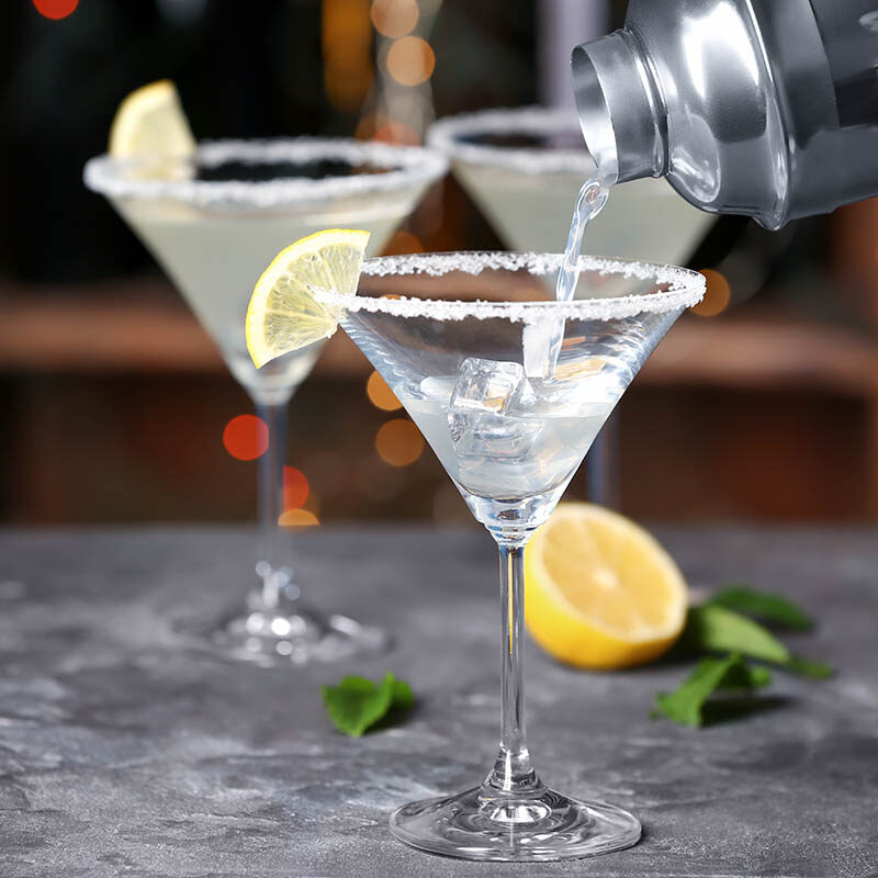 Lemon drop martini cocktail into glass on table